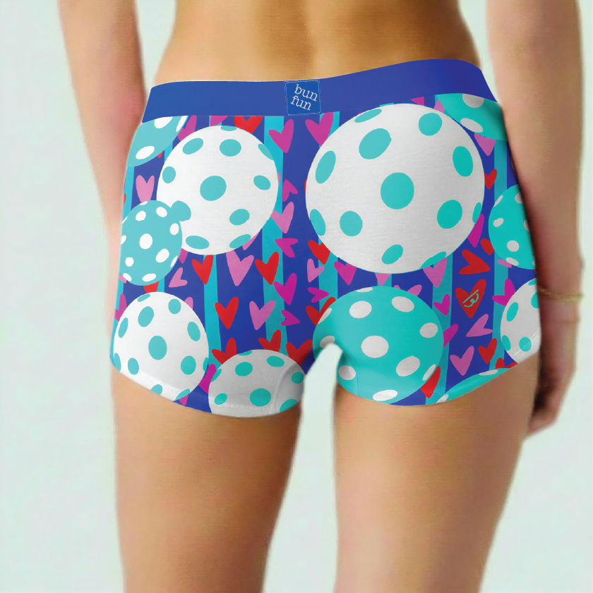 Colorful patterned underwear with polka dots and hearts on a plain background