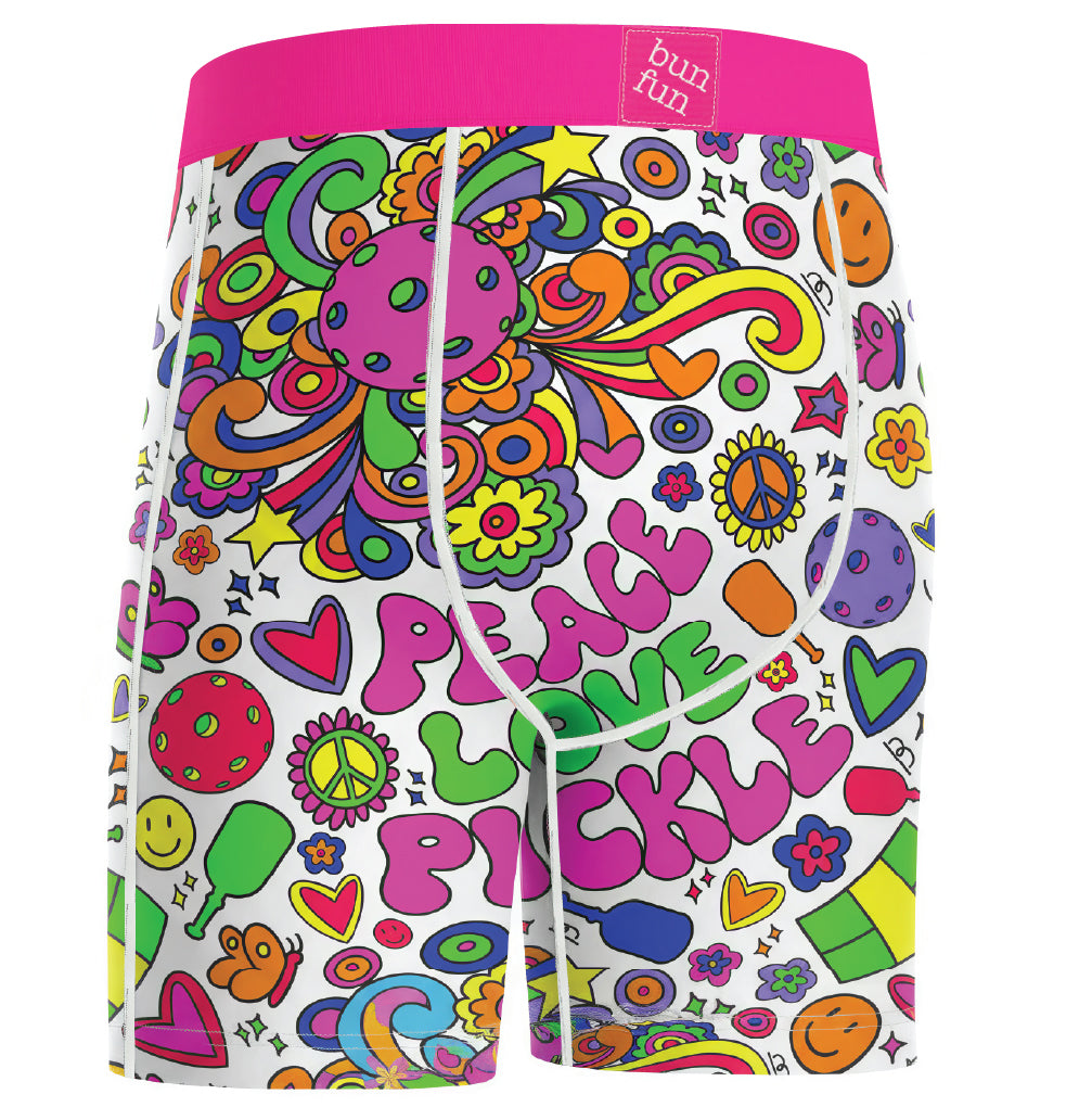 White boxer briefs with a vibrant pink waistband and a colorful retro psychedelic print featuring the words 'PEACE LOVE PICKLE' in bubble letters, surrounded by flowers, peace signs, and smiley faces. The brand label 'bun fun' is visible on the waistband.