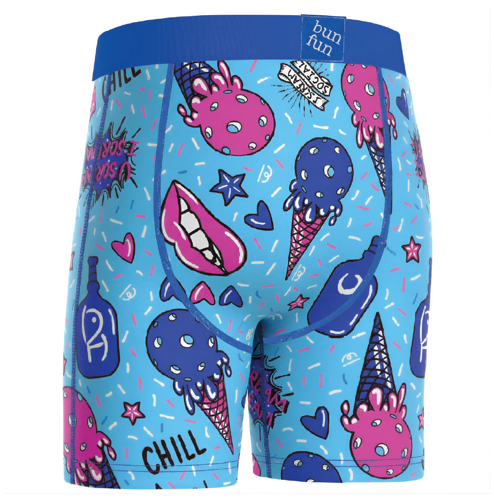 A pair of men's boxer briefs featuring a vibrant blue base with a colorful cartoon ice cream and candy print. The waistband is solid blue, and the front has illustrations of pink and blue ice cream cones, a pink mouth with teeth, hearts, stars, and the word 'CHILL'.
