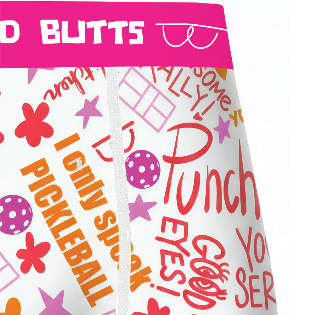 Close-up of a white novelty garment printed with colorful text and graphics, including a bright pink waistband with white text and red, orange, pink, and purple lettering on the body.